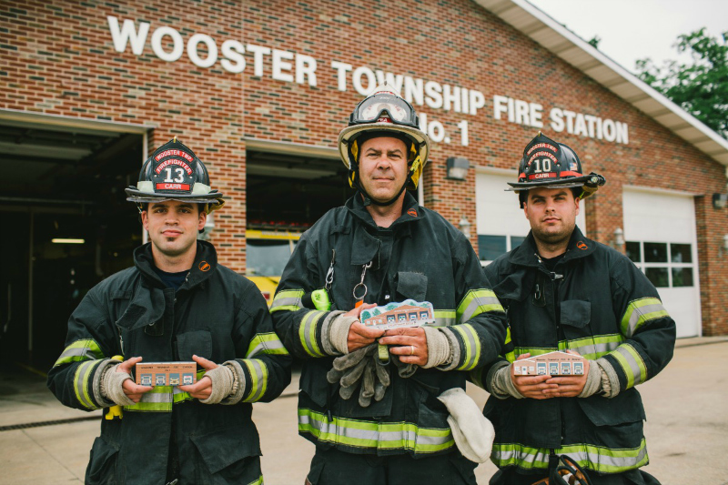 Wooster Township firefighters holding Cat's Meow replicas of their fire station.