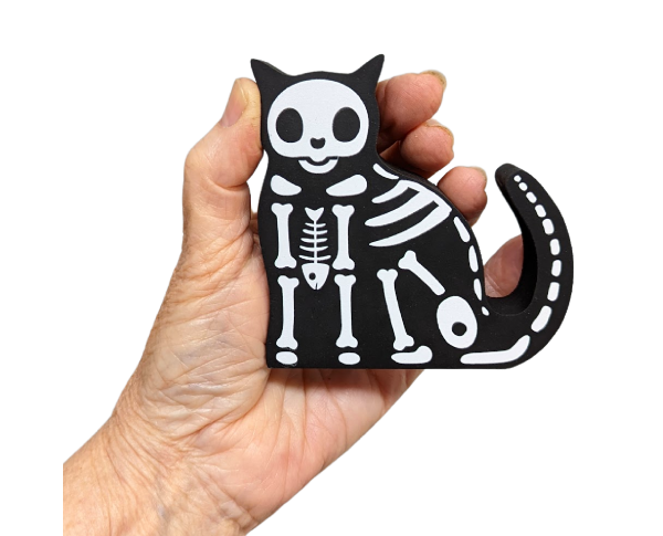 Casper our mascot really does have a backbone! He's all ready to go for Halloween with his skeleton attire!. Handcrafted in Wooster, Ohio by The Cat's Meow Village.